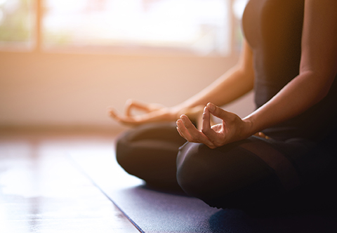 Someone cross-legged, practicing meditation